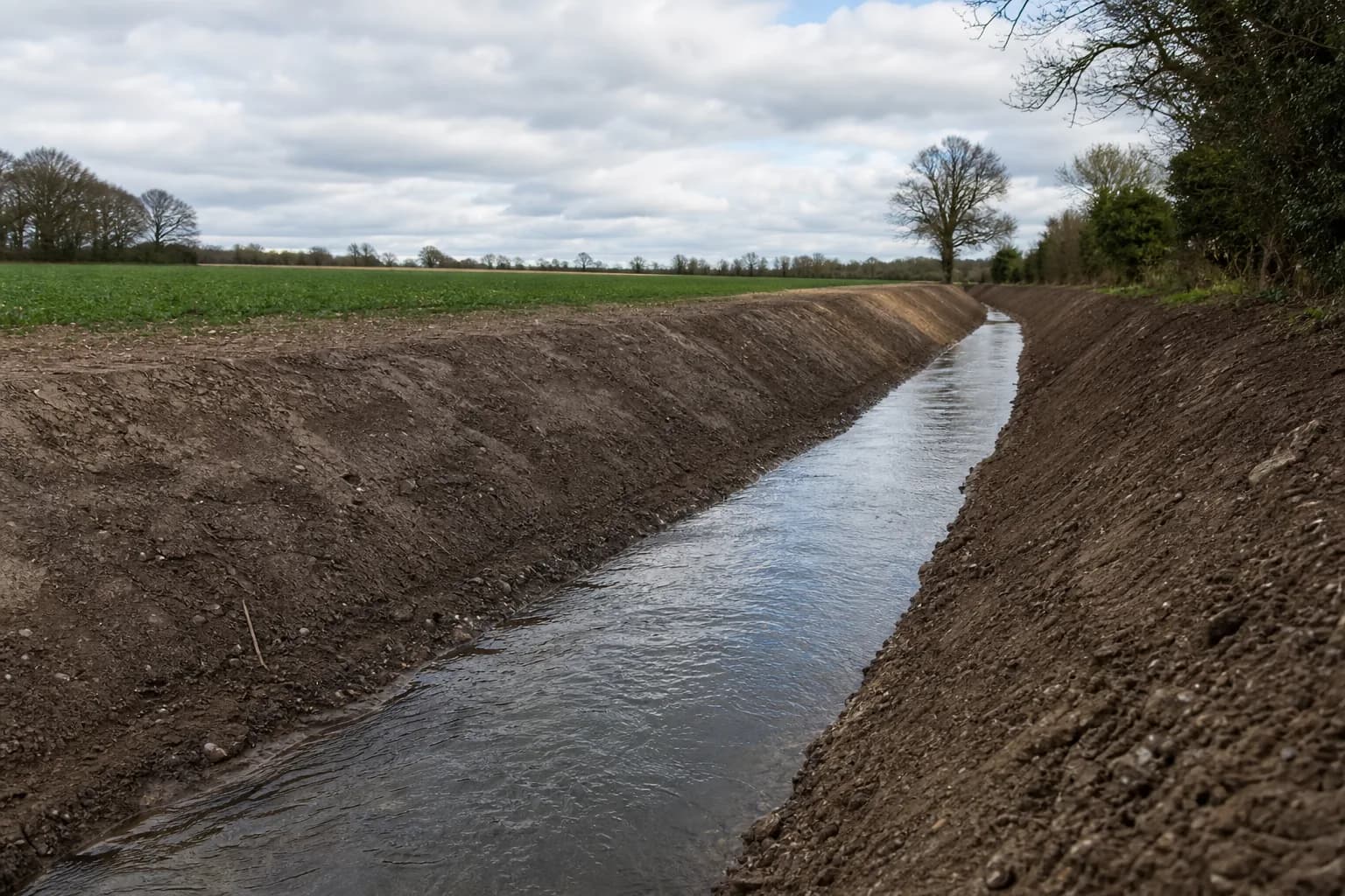 Rural drainage ditch cleared and reinstated alongside farmland